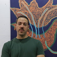 a man with a mustache standing in front of a painting
